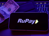 A laptop keyboard, a banknote, a wallet and RuPay logo displayed on a phone screen are seen in this illustration photo taken in Krakow, Pola...