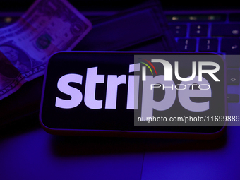 A laptop keyboard, a banknote, a wallet and Stripe logo displayed on a phone screen are seen in this illustration photo taken in Krakow, Pol...