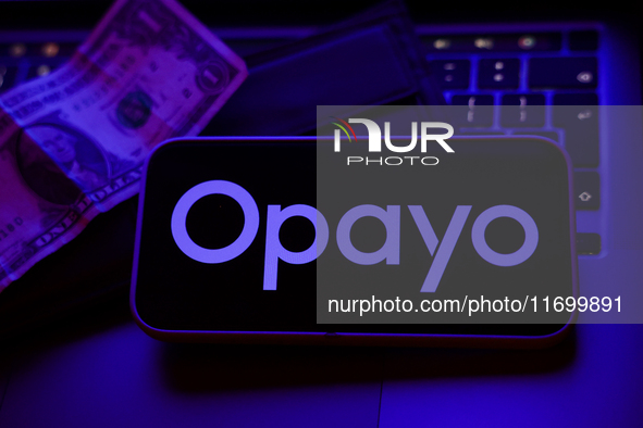 A laptop keyboard, a banknote, a wallet and Opayo logo displayed on a phone screen are seen in this illustration photo taken in Krakow, Pola...