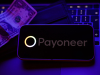 A laptop keyboard, a banknote, a wallet and Payoneer logo displayed on a phone screen are seen in this illustration photo taken in Krakow, P...