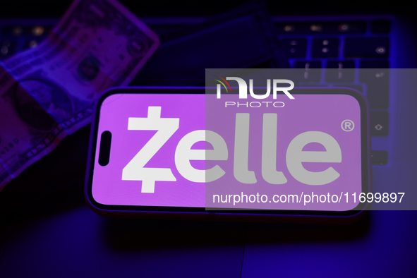 A laptop keyboard, a banknote, a wallet and Zelle logo displayed on a phone screen are seen in this illustration photo taken in Krakow, Pola...