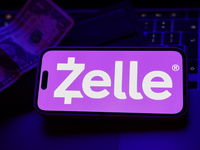 A laptop keyboard, a banknote, a wallet and Zelle logo displayed on a phone screen are seen in this illustration photo taken in Krakow, Pola...