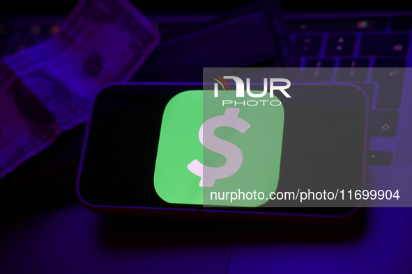 A laptop keyboard, a banknote, a wallet and Cash App logo displayed on a phone screen are seen in this illustration photo taken in Krakow, P...