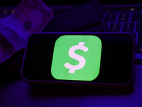 A laptop keyboard, a banknote, a wallet and Cash App logo displayed on a phone screen are seen in this illustration photo taken in Krakow, P...