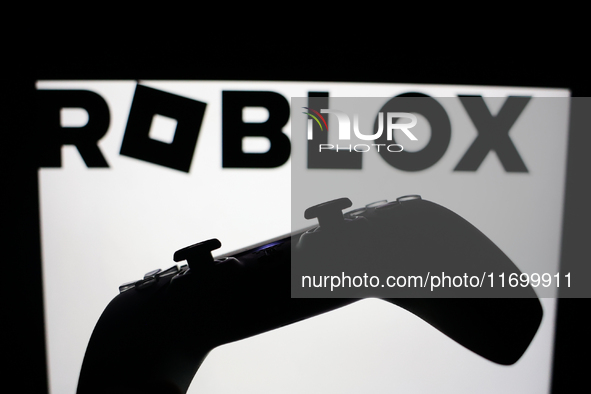 Roblox logo displayed on a laptop screen and DualSense controller are seen in this illustration photo taken in Krakow, Poland on October 23,...