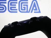 Sega logo displayed on a laptop screen and DualSense controller are seen in this illustration photo taken in Krakow, Poland on October 23, 2...