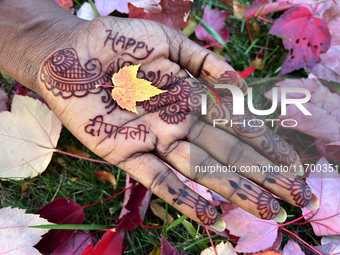 A woman holds a small colorful maple leaf in her hand during the autumn season in Toronto, Ontario, Canada, on October 22, 2024. (