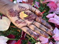 A woman holds a small colorful maple leaf in her hand during the autumn season in Toronto, Ontario, Canada, on October 22, 2024. (