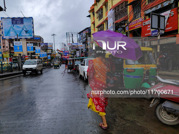 A woman holds an umbrella while walking on the street during rain due to Cyclone Dana in Kolkata, India, on October 24, 2024. 