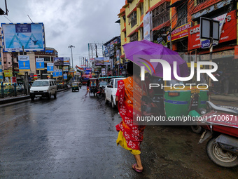 A woman holds an umbrella while walking on the street during rain due to Cyclone Dana in Kolkata, India, on October 24, 2024. (