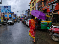 A woman holds an umbrella while walking on the street during rain due to Cyclone Dana in Kolkata, India, on October 24, 2024. (