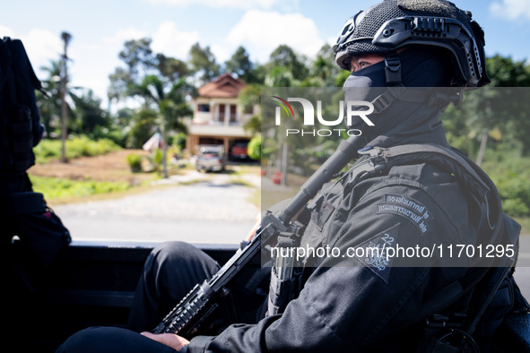 A sniper rides on the back of a truck. Special Forces, the Black Army, and Volunteer Force Operations in Thailand's Deep South perform intel...