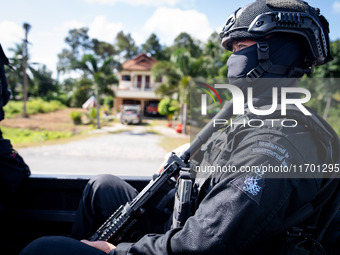 A sniper rides on the back of a truck. Special Forces, the Black Army, and Volunteer Force Operations in Thailand's Deep South perform intel...