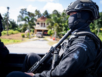 A sniper rides on the back of a truck. Special Forces, the Black Army, and Volunteer Force Operations in Thailand's Deep South perform intel...