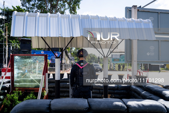 An armed soldier next to bulletproof glass works at a checkpoint in Pattani. Special Forces, the Black Army, and Volunteer Force Operations...