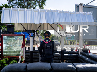 An armed soldier next to bulletproof glass works at a checkpoint in Pattani. Special Forces, the Black Army, and Volunteer Force Operations...