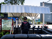 An armed soldier next to bulletproof glass works at a checkpoint in Pattani. Special Forces, the Black Army, and Volunteer Force Operations...