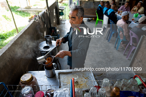 A vendor makes tea for the community while meeting with the army to check on the situation in their village near Pattani. Special Forces, th...