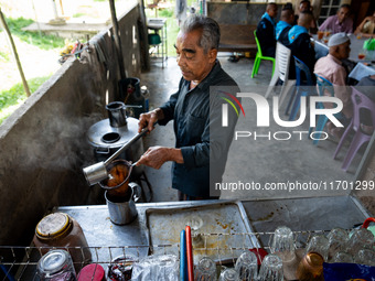 A vendor makes tea for the community while meeting with the army to check on the situation in their village near Pattani. Special Forces, th...