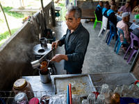 A vendor makes tea for the community while meeting with the army to check on the situation in their village near Pattani. Special Forces, th...