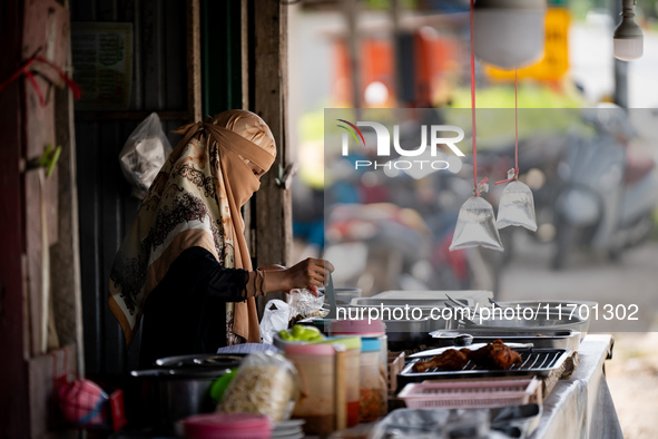 A street food vendor prepares lunch by the road in Pattani. Special Forces, the Black Army, and Volunteer Force Operations in Thailand's Dee...