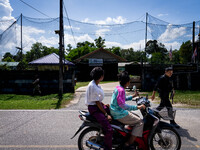 People on a motorcycle pass by an army base in Pattani. Special Forces, the Black Army, and Volunteer Force Operations in Thailand's Deep So...