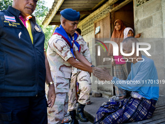 Members of the army and volunteer task force provide healthcare and other necessary supplies to families in need in villages around Pattani....