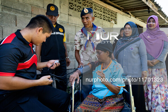 Members of the army and volunteer task force provide healthcare and other necessary supplies to families in need in villages around Pattani....