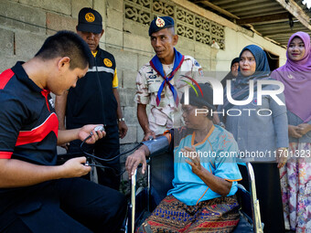 Members of the army and volunteer task force provide healthcare and other necessary supplies to families in need in villages around Pattani....