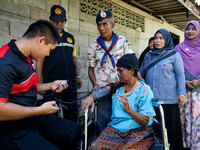 Members of the army and volunteer task force provide healthcare and other necessary supplies to families in need in villages around Pattani....