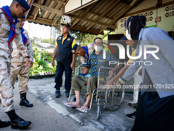 Members of the army and volunteer task force provide healthcare and other necessary supplies to families in need in villages around Pattani....