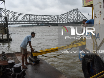 Workers tie a boat to a jetty as a precautionary measure against Cyclone Dana in Kolkata, India, on October 24, 2024. The Regional Meteorolo...