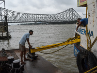 Workers tie a boat to a jetty as a precautionary measure against Cyclone Dana in Kolkata, India, on October 24, 2024. The Regional Meteorolo...