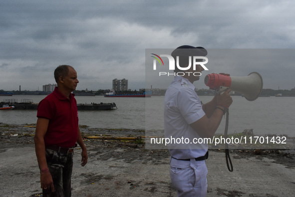 Police officials patrol a riverside in Kolkata, India, on October 24, 2024, as a precautionary measure ahead of the landfall of Cyclone Dana...