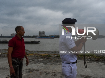 Police officials patrol a riverside in Kolkata, India, on October 24, 2024, as a precautionary measure ahead of the landfall of Cyclone Dana...