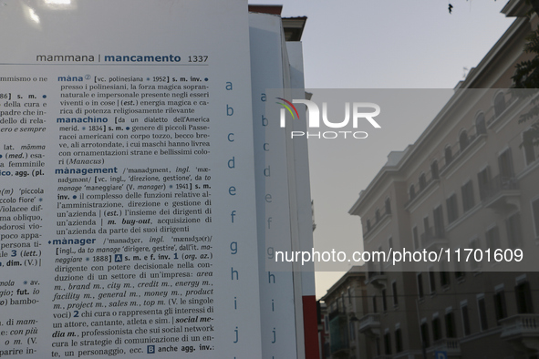 Two people observe a public art installation representing a monumental-sized dictionary in an urban space in Bari, Italy, on October 20, 201...