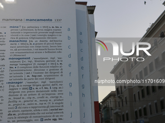 Two people observe a public art installation representing a monumental-sized dictionary in an urban space in Bari, Italy, on October 20, 201...