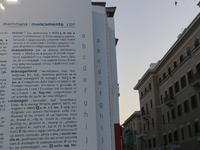 Two people observe a public art installation representing a monumental-sized dictionary in an urban space in Bari, Italy, on October 20, 201...