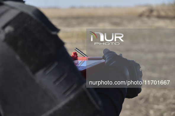 A rescuer holds a remote control during humanitarian demining using the latest devices in the Kharkiv region, Ukraine, on October 23, 2024. 