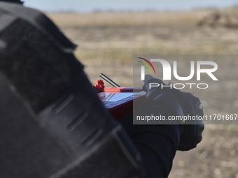 A rescuer holds a remote control during humanitarian demining using the latest devices in the Kharkiv region, Ukraine, on October 23, 2024....