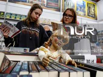 Young adults browse on a book stand during the 27. International Book Fair in The International Exhibition and Convention Centre EXPO in Kra...