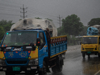 People cover themselves with polythene as they ride on a truck during rain in Dhaka, Bangladesh, on October 24, 2024. Light rain and wind fr...