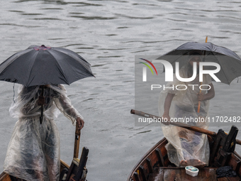 Boatmen wait for passengers at the river Buriganga during rain in Dhaka, Bangladesh, on October 24, 2024. Light rain and wind from Cyclone D...