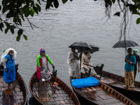 Boatmen wait for passengers at the river Buriganga during rain in Dhaka, Bangladesh, on October 24, 2024. Light rain and wind from Cyclone D...