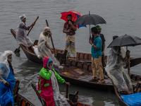 Passengers hold umbrellas as they cross the Buriganga River during rain in Dhaka, Bangladesh, on October 24, 2024. Light rain and wind from...