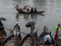 Passengers hold umbrellas as they cross the Buriganga River during rain in Dhaka, Bangladesh, on October 24, 2024. Light rain and wind from...