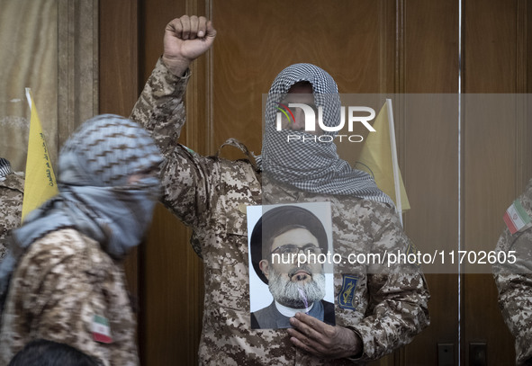 An Islamic Revolutionary Guard Corps (IRGC) military personnel, wearing a Palestinian scarf and a uniform symbolizing Hamas warriors, shouts...