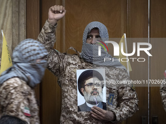 An Islamic Revolutionary Guard Corps (IRGC) military personnel, wearing a Palestinian scarf and a uniform symbolizing Hamas warriors, shouts...