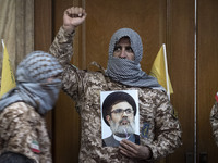 An Islamic Revolutionary Guard Corps (IRGC) military personnel, wearing a Palestinian scarf and a uniform symbolizing Hamas warriors, shouts...