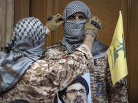 An Islamic Revolutionary Guard Corps (IRGC) military personnel, wearing a Palestinian scarf and a uniform symbolizing Hamas warriors, holds...